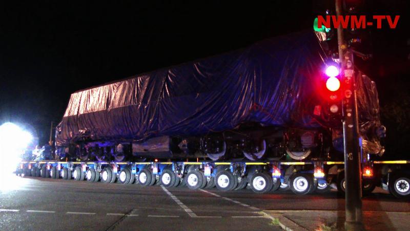 Modernste Bahntechnik unter blauen Planen: Nächtlicher Schwertransport bringt rund 120 Tonnen schwere Lokomotive zum Berliner Messegelände – Verhülltes Fahrzeug soll zur InnoTrans-Präsentation einer 2.000-kW-Wasserstoff-Brennstoffzellen-Hybridlokomotive von CRRC gehören – Moderne Lok kombiniert leistungsstarke Brennstoffzellen mit Traktionsbatterien und KI-gestützter 360-Grad-Umfelderkennung – Zwei zugehörige Waggons wiegen jeweils weitere 40 Tonnen