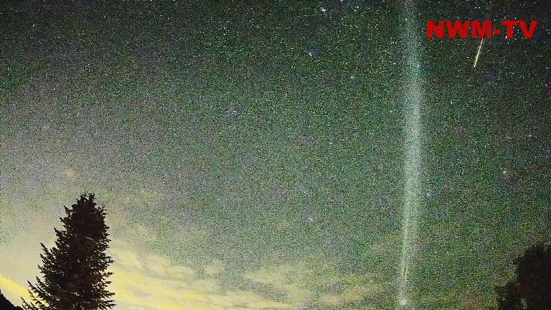 Phänomen am Nachthimmel - helle Leuchtspur zieht über den morgendlichen Sternenhimmel - wahrscheinlich handelt es sich um eine Raketenspur - während am Boden noch Nacht herrscht wird die Treibstoffwolke in der Höhe bereits von der Sonne beleuchtet